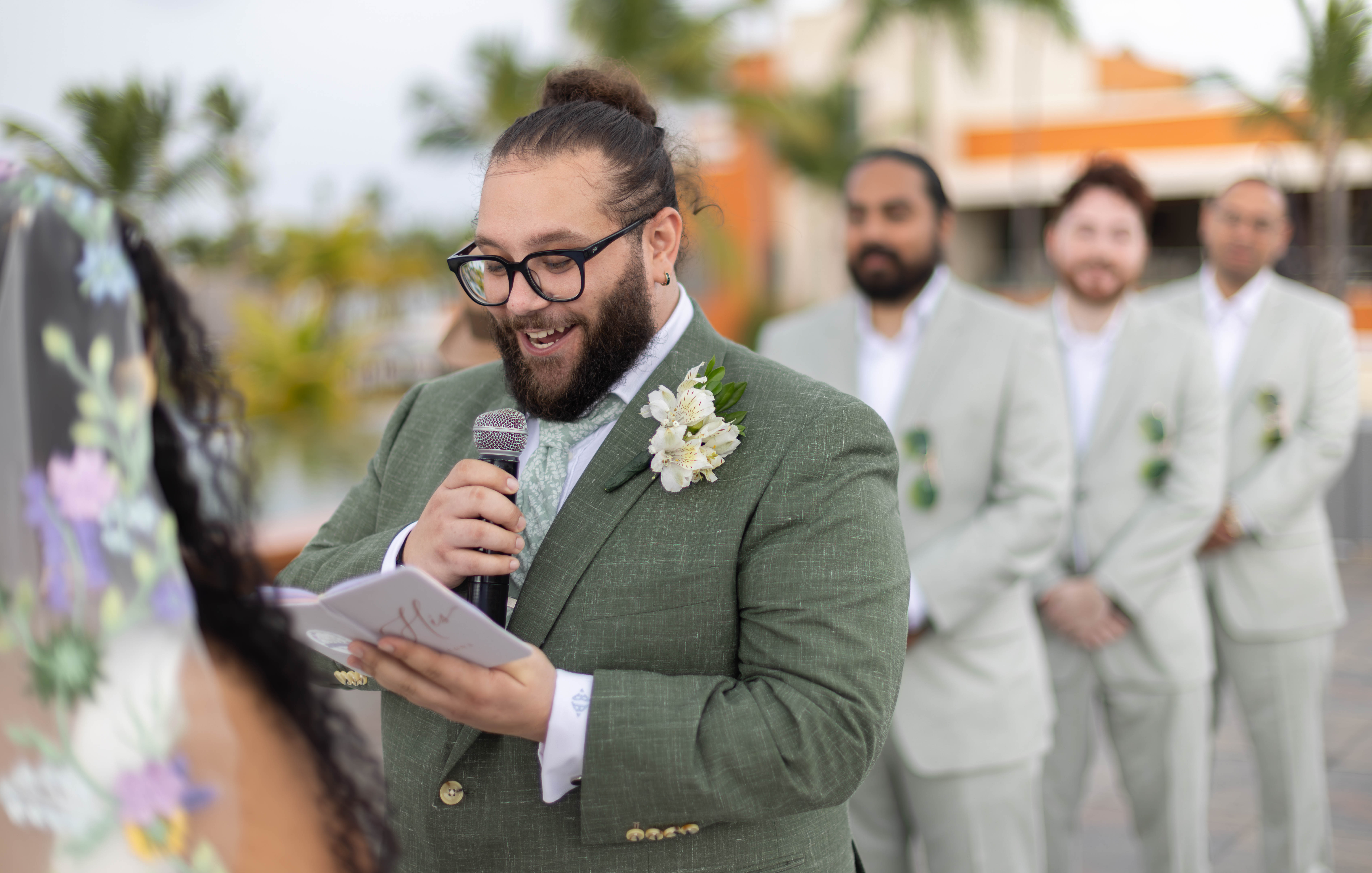 Groom's speech under tropical sky Groom in mint-green suit and glasses delivers speech at Santo Domingo wedding ceremony, surrounded by groomsmen