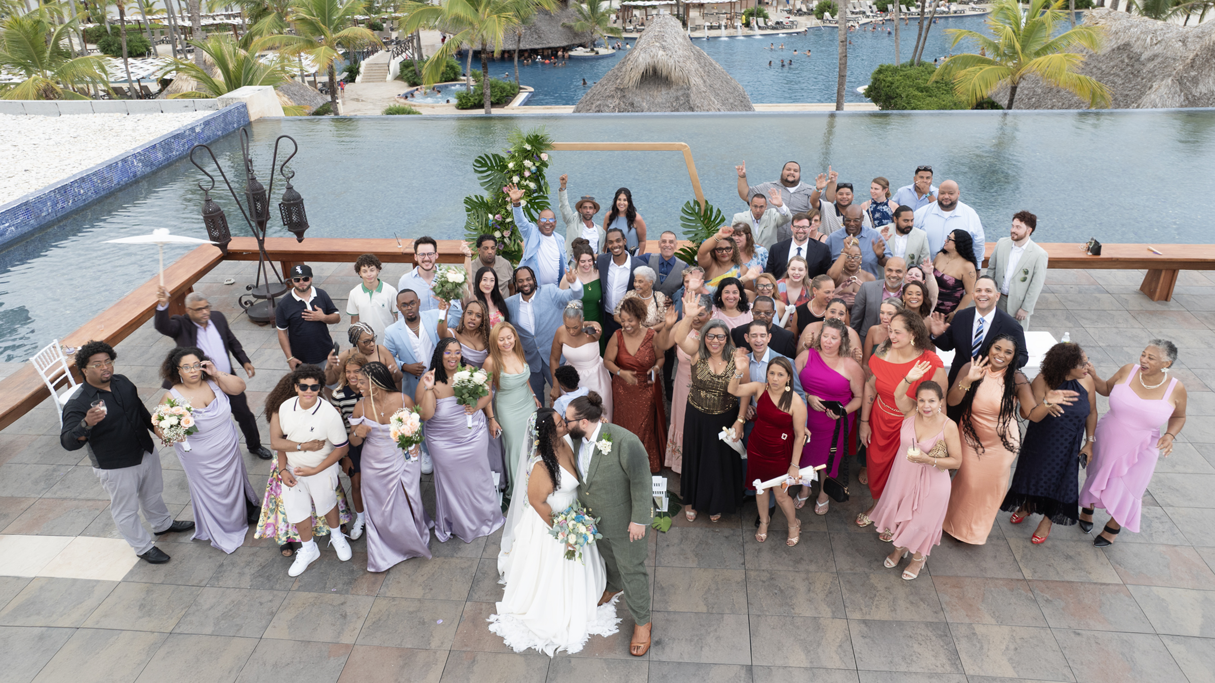 Large wedding by the Punta Cana lagoon Wedding session with seventy guests in Punta Cana by a lagoon, bride in white and groom in sage green, professional wedding photographer