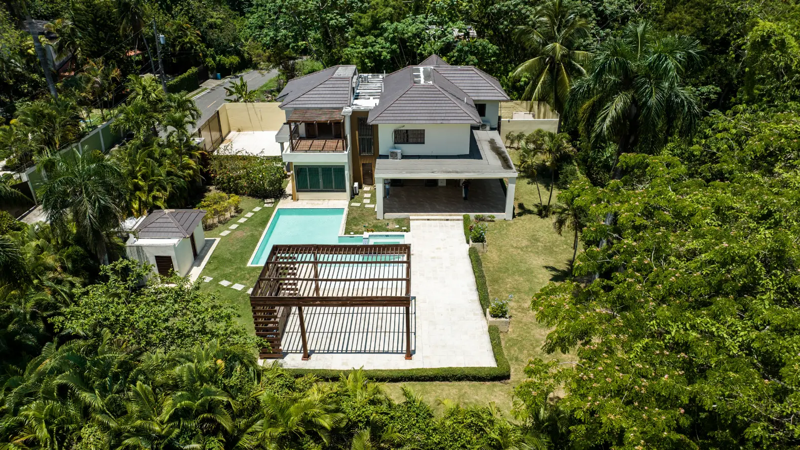 Mansión de lujo vista desde el cielo Fotografía aérea con dron de mansión de lujo en Santo Domingo con piscina turquesa, terraza blanca y jardines tropicales exuberantes desde perspectiva cenital