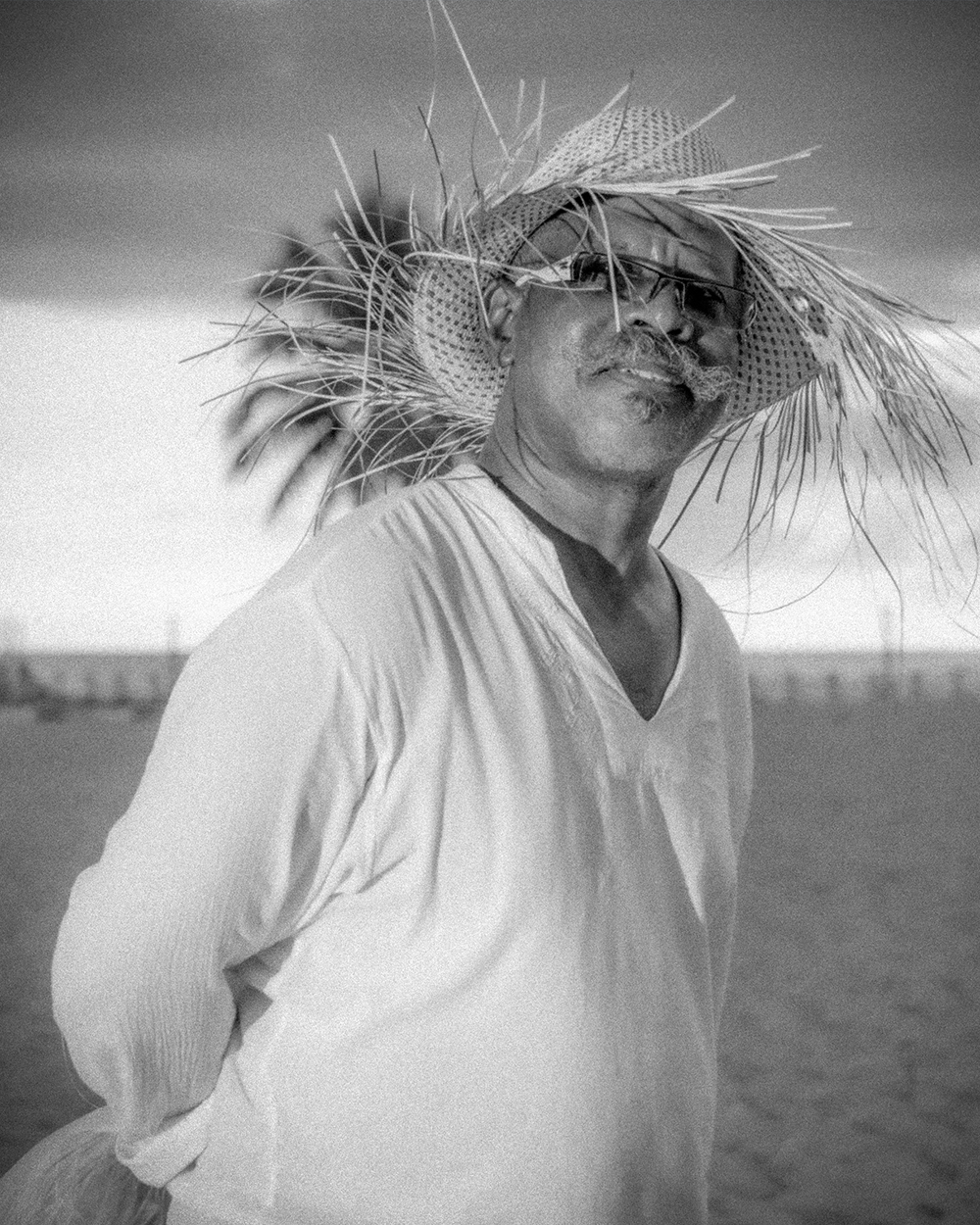 Retrato Luxury en Playa, Luz Natural Retrato luxury en blanco y negro de hombre mirando al cielo en playa de Santo Domingo con palma real y camisa blanca ondeante