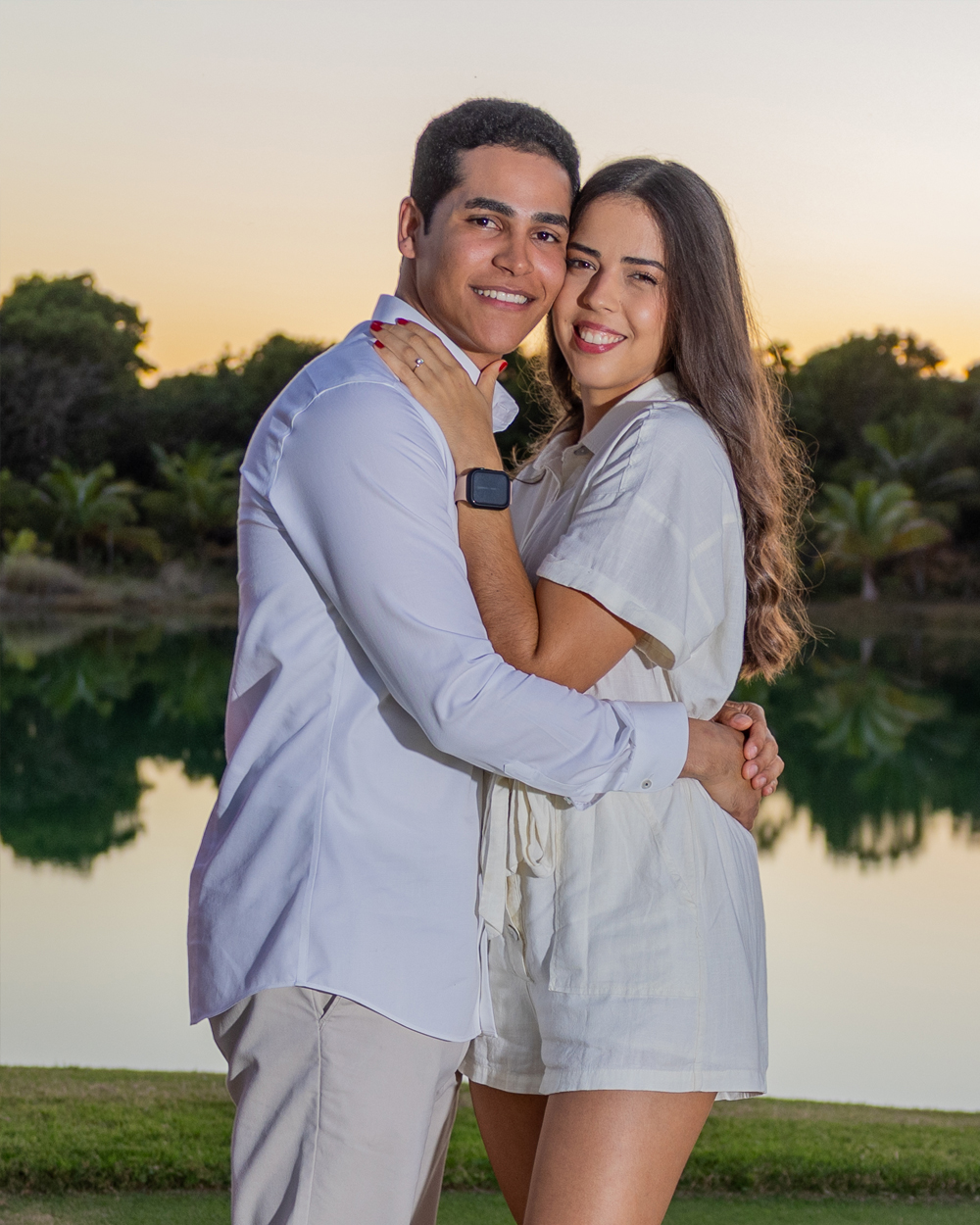 Engagement at sunset by the water Couple in engagement session embracing at sunset by still lagoon, golden light, engagement photographer Santo Domingo