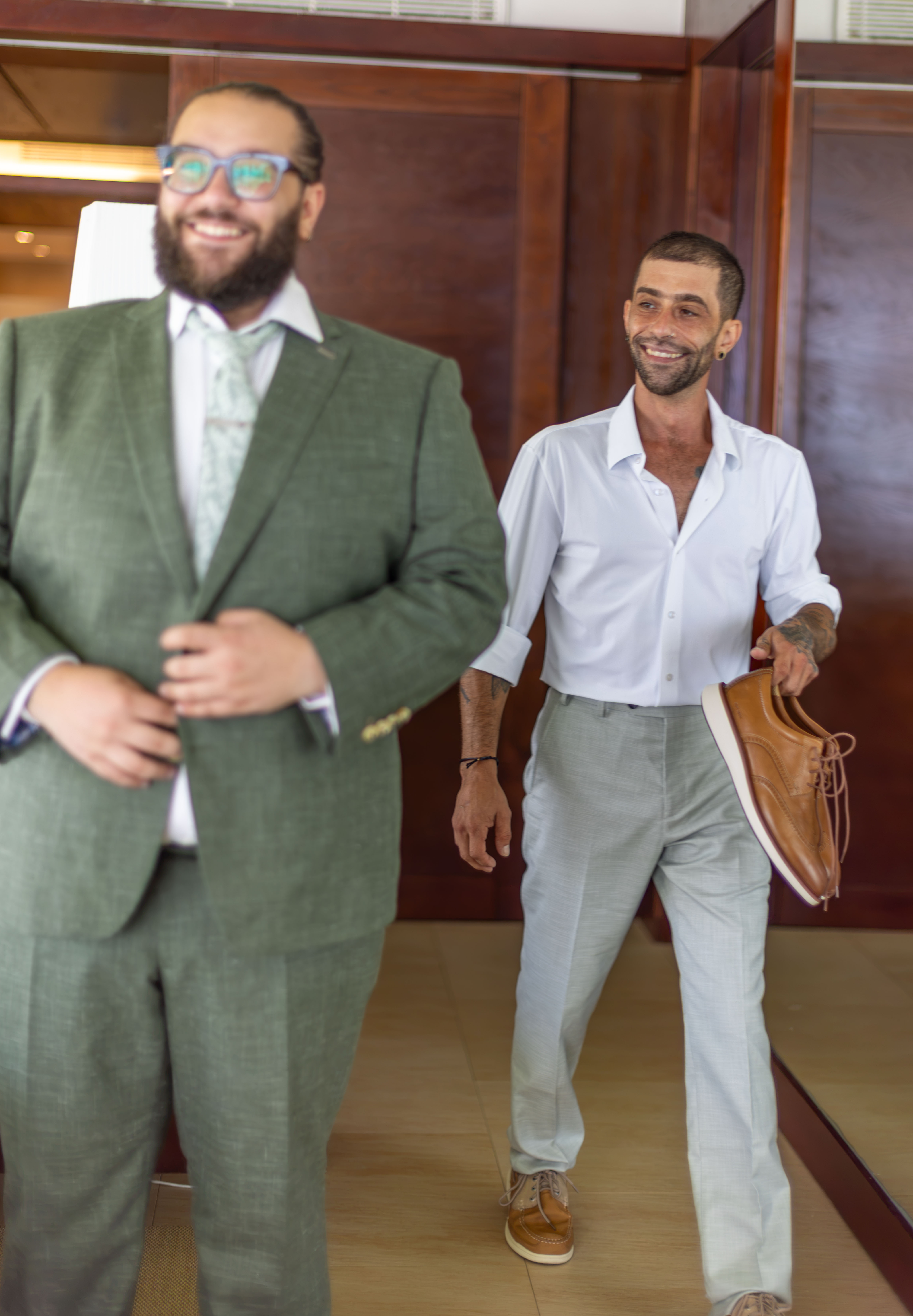 Executive portraits in corporate foyer Two professional executives smile while walking in an elegant corporate foyer in Santo Domingo with mahogany walls and golden light