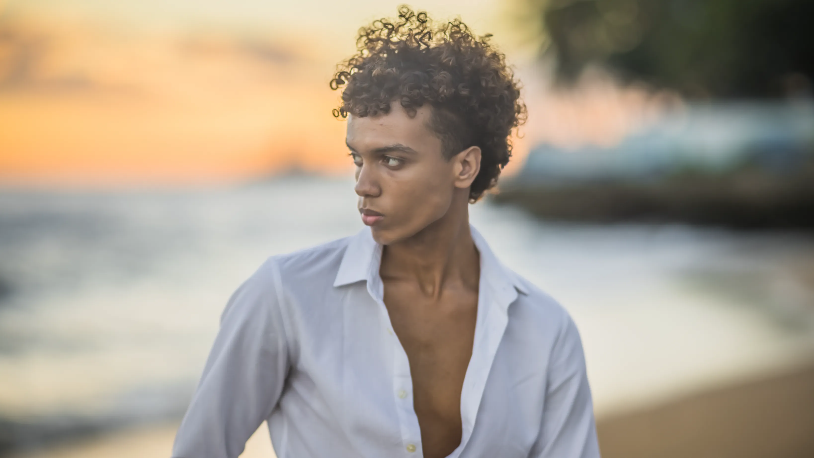 Golden Portrait on Santo Domingo Beach Luxury beach portrait at sunset: young man in white shirt facing the Atlantic Ocean in Santo Domingo