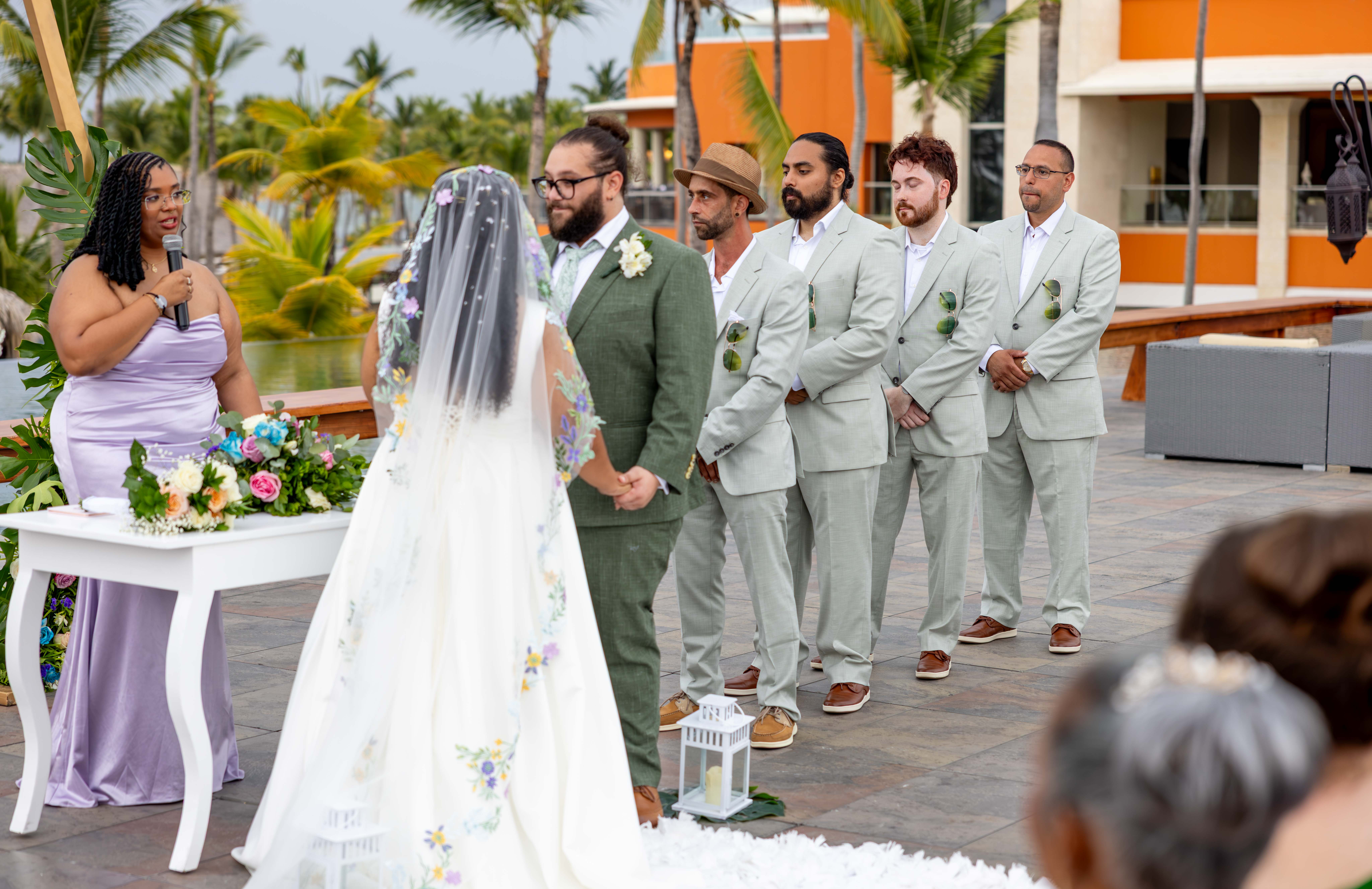 Wedding ceremony on Santo Domingo rooftop terrace Wedding photography in Santo Domingo: bride in embroidered veil and groom waiting at ceremony with modern architecture backdrop